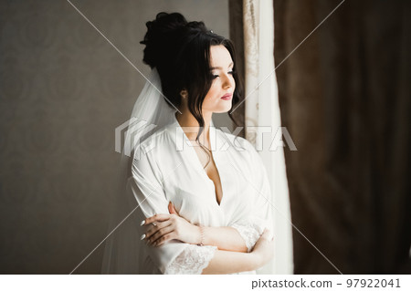Luxury bride in white dress posing while preparing for the wedding ceremony Luxury bride in white dress posing while preparing for the wedding ceremony 97922041