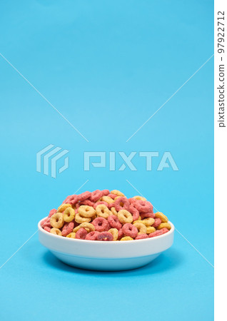 Quick cereal breakfast in the form of rings on a plate on a blue background Quick cereal breakfast in the form of rings on a plate on a blue background 97922712
