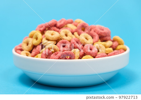 Quick cereal breakfast in the form of rings on a plate on a blue background 97922713