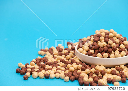 Corn sweet balls on a blue background with place for text. Quick dry breakfasts, side view. Corn sweet balls on a blue background with place for text. Quick dry breakfasts, side view. 97922720
