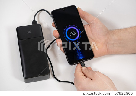 Connecting a mobile phone to a power bank. Charging gadgets from power banks. 97922809