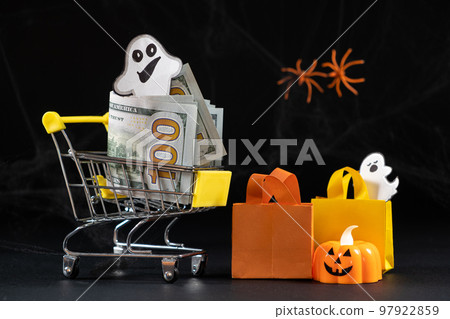 Cart with money hundred-dollar bills, paper bags for purchases. Halloween Sale Cart with money hundred-dollar bills, paper bags for purchases. Halloween Sale 97922859