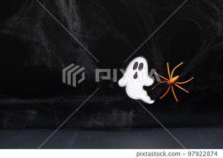 A frightening white ghost flies on a black background with a web and spider, a Halloween postcard A frightening white ghost flies on a black background with a web and spider, a Halloween postcard 97922874