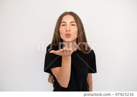 Portrait of flirty young woman sending air kiss Portrait of flirty young woman sending air kiss 97923216
