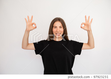 Portrait of cheerful young woman making okay gesture Portrait of cheerful young woman making okay gesture 97923231
