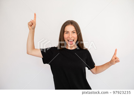 Portrait of excited happy young woman pointing upwards 97923235