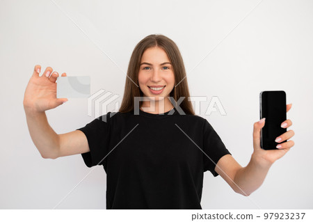 Portrait of happy young woman showing smartphone and credit card Portrait of happy young woman showing smartphone and credit card 97923237
