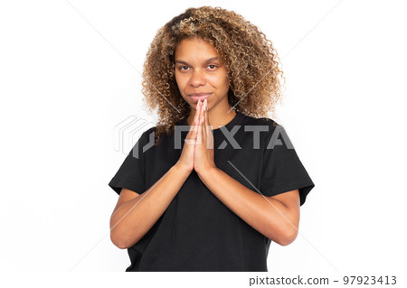 Pleased African American woman pressing hands together 97923413