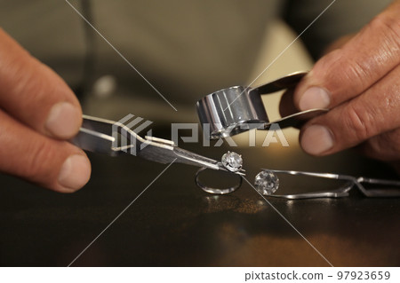 Professional jeweler working with beautiful ring at table, closeup Professional jeweler working with beautiful ring at table, closeup 97923659