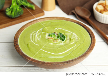 Delicious broccoli cream soup served on white wooden table, closeup Delicious broccoli cream soup served on white wooden table, closeup 97923762