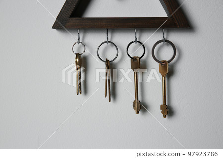 Wooden key holder on light grey wall Wooden key holder on light grey wall 97923786