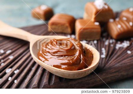 Salted caramel in spoon on board, closeup 97923809