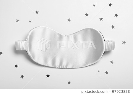 Sleeping mask and glitter on white background, top view. Bedtime accessory Sleeping mask and glitter on white background, top view. Bedtime accessory 97923828