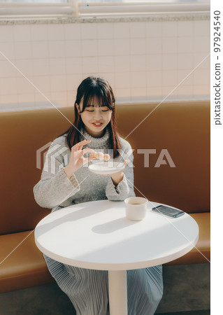 女大學生在咖啡館吃甜甜圈 女大學生在咖啡館吃甜甜圈 97924540