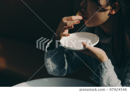 Female college student eating donuts in a cafe Female college student eating donuts in a cafe 97924546