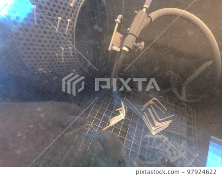 Shot blasting. Shot blasting of model printed on 3D printer from polyamide powder. A worker in sealed rubber gloves cleans the object by shot blasting in a shot blasting chamber. Industrial machine Shot blasting. Shot blasting of model printed on 3D printer from polyamide powder. A worker in sealed rubber gloves cleans the object by shot blasting in a shot blasting chamber. Industrial machine 97924622
