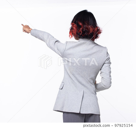 Half body Tanned skin Asian Indian woman points finger hand up to Sky, Business Blazer female turn rear back side hold tablet to future empty area air, studio white background isolated 97925154