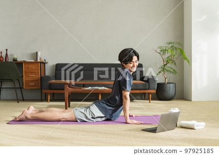 Man stretching his waist at home Man stretching his waist at home 97925185