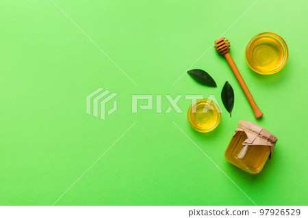Honey jar with wooden honey dipper on white background top view with copy space. Delicious honey bottle Honey jar with wooden honey dipper on white background top view with copy space. Delicious honey bottle 97926529