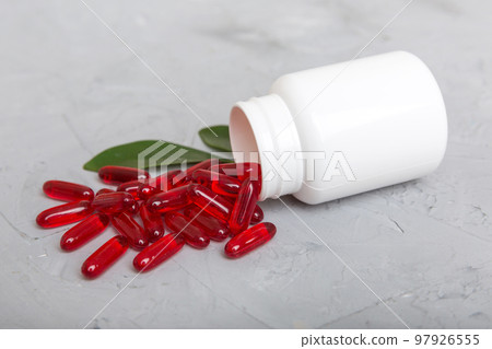 different drugs and health supplement pills poured from a medicine bottle health care and medical top view on colored background 97926555