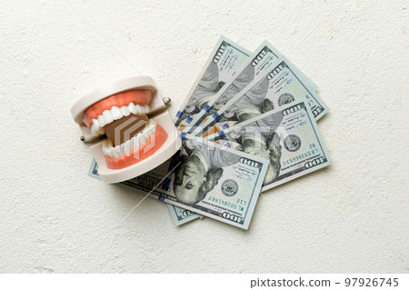Closeup model of a human jaw with white teeth and dollar bill. Dentistry conceptual photo. Prosthetic dentistry. False teet top view with copy space 97926745