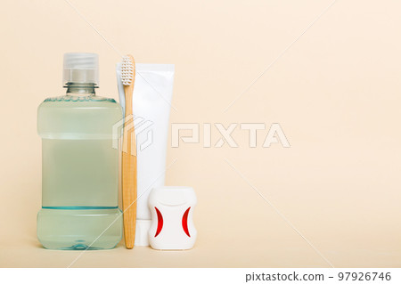 Mouthwash and other oral hygiene products on colored table top view with copy space. Flat lay. Dental hygiene. Oral care products and space for text on light background. concept 97926746
