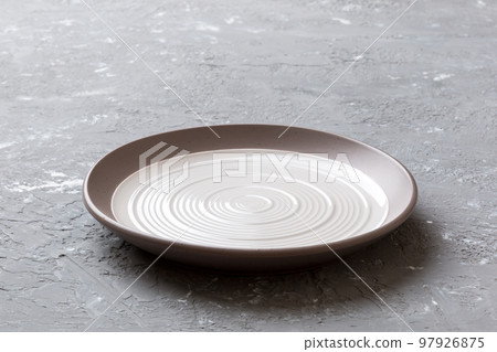 Perspective view of empty light plate on cement background. Empty space for your design Perspective view of empty light plate on cement background. Empty space for your design 97926875