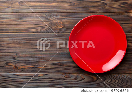 Top view of empty red plate on wooden background. Empty space for your design Top view of empty red plate on wooden background. Empty space for your design 97926896