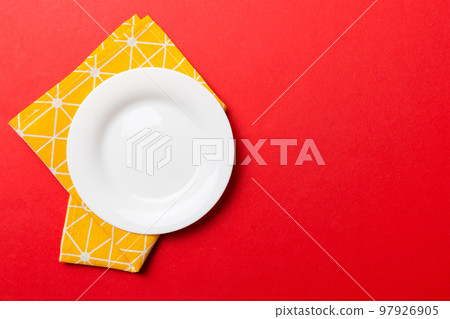 Top view on colored background empty round white plate on tablecloth for food. Empty dish on napkin with space for your design Top view on colored background empty round white plate on tablecloth for food. Empty dish on napkin with space for your design 97926905