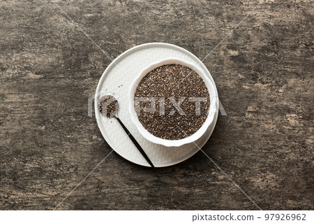 Chia seeds in bowl and spoon on colored background. Healthy Salvia hispanica in small bowl. Healthy superfood Chia seeds in bowl and spoon on colored background. Healthy Salvia hispanica in small bowl. Healthy superfood 97926962
