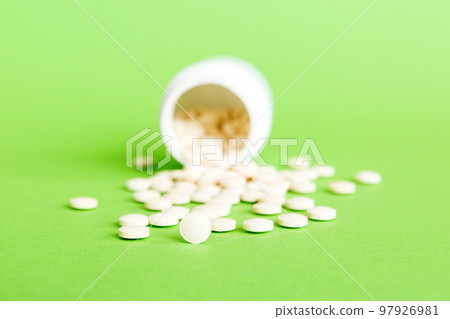 Medicine bottle and white pills spilled on a light background. Medicines and prescription pills flat lay background. White medical pills and tablets spilling out of a drug bottle Medicine bottle and white pills spilled on a light background. Medicines and prescription pills flat lay background. White medical pills and tablets spilling out of a drug bottle 97926981