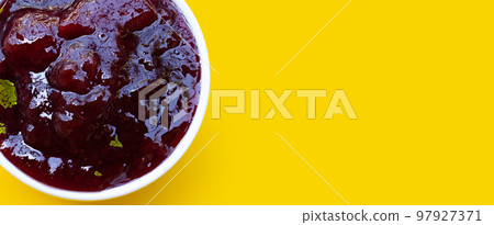 Strawberry jam on yellow background. 97927371