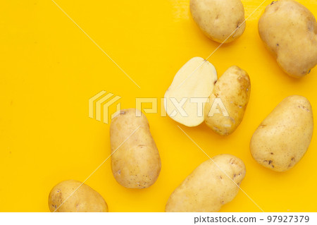 Raw potatoes isolated on yellow background Raw potatoes isolated on yellow background 97927379