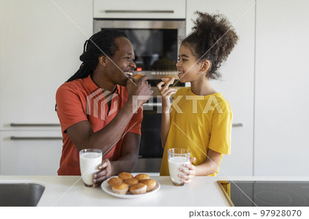 Happy Black Father And Daughter Eating Snacks And Having Fun In Kitchen 97928070
