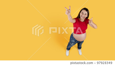 Above Shot Of Pregnant Woman Pointing At Copy Space On Yellow Background 97928349