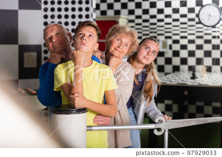 Grandparents and kids standing in row in escape room 97929033