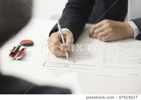 簽訂房地產合同的兩名婦女的手 97929827