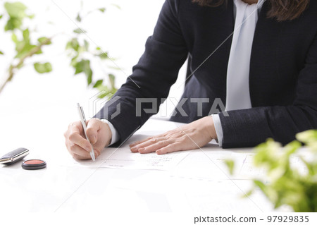 簽訂房地產合同的兩名婦女的手 97929835