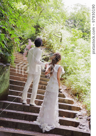 Back view of the bride and groom pledging their future Back view of the bride and groom pledging their future 97930190