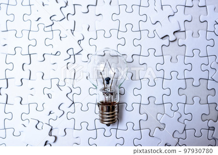 Sparking ideas Background textures of scattered jigsaw puzzles and light bulbs Strategies Cold colors 97930780
