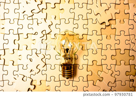Sparking ideas Background texture of scattered jigsaw puzzles and light bulbs Strategy Gold 97930781