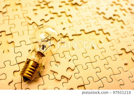Sparking ideas Background texture of scattered jigsaw puzzles and light bulbs Strategy Gold 97931218