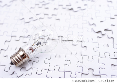 Sparking ideas Background texture of scattered jigsaw puzzles and light bulbs Strategy bright 97931336