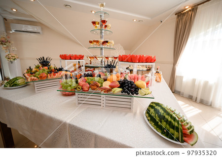 Festive table set with food and drinks. Festive table set with food and drinks. 97935320