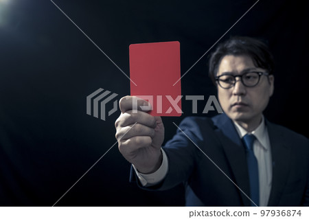 Male business person presenting a red card Male business person presenting a red card 97936874