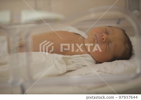 Neonatology. A newborn in a special incubator for babies in a hospital. Neonatology. A newborn in a special incubator for babies in a hospital. 97937644