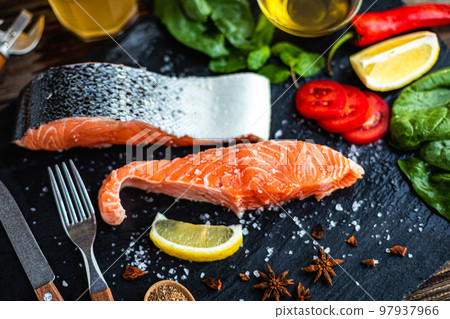 Top view of raw salmon fish fillet with ingredients for cook on slate cutting board. Selective focus Top view of raw salmon fish fillet with ingredients for cook on slate cutting board. Selective focus 97937966