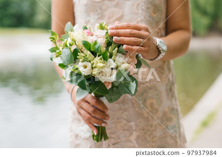Beautiful rustic wedding bouquet in the hands of the bride 97937984