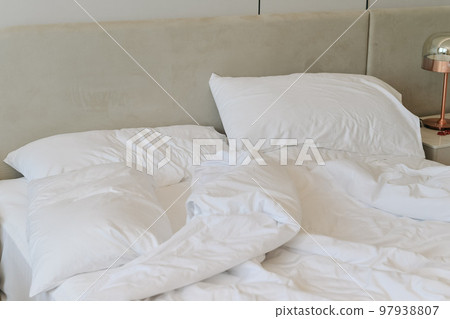 Unmade bedding sheets and pillow. Unmade messy bed after comfortable sleep concept Unmade bedding sheets and pillow. Unmade messy bed after comfortable sleep concept 97938807