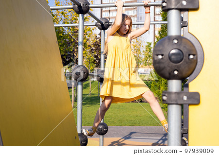 girl at the  large beautiful playground in the park 97939009